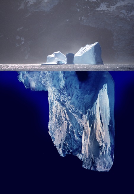 Landscape photo shows an iceberg. Below the water, the iceberg continues to deepen.