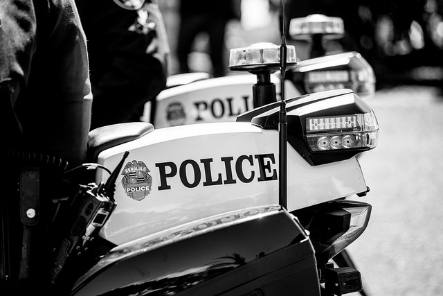 Black and white photo displaying two police motor bikes.