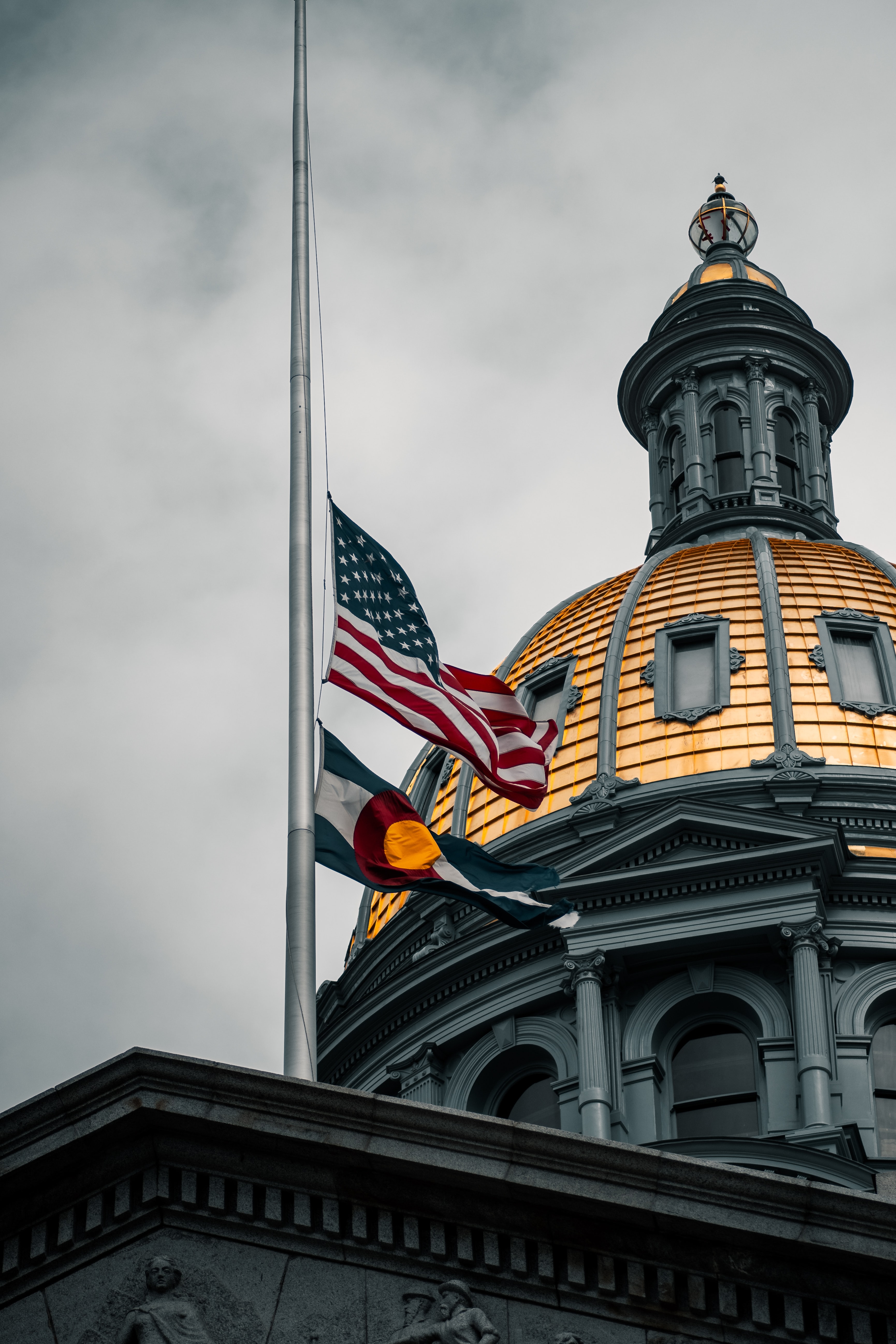 colorado state capitol with both the american and colorado flag