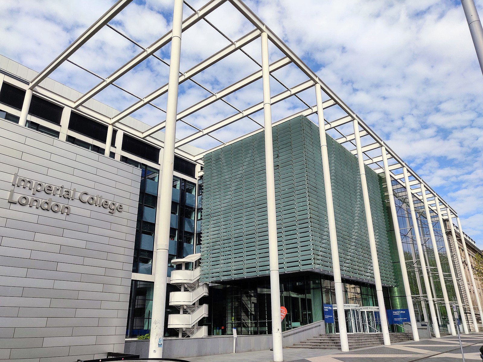 the building entrance reading "Imperial College London" with blue sky and clouds in the background