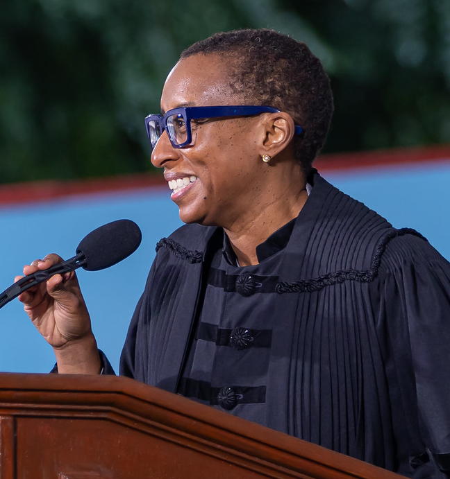Claudine Gay in academic dress speaks into microphone at a podium