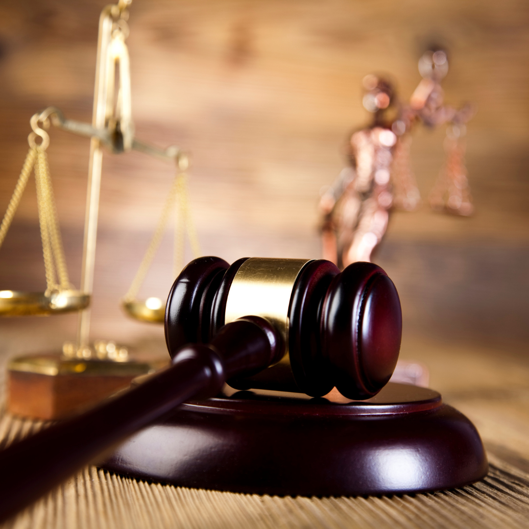 brown wooden gavel with scales of justice in background