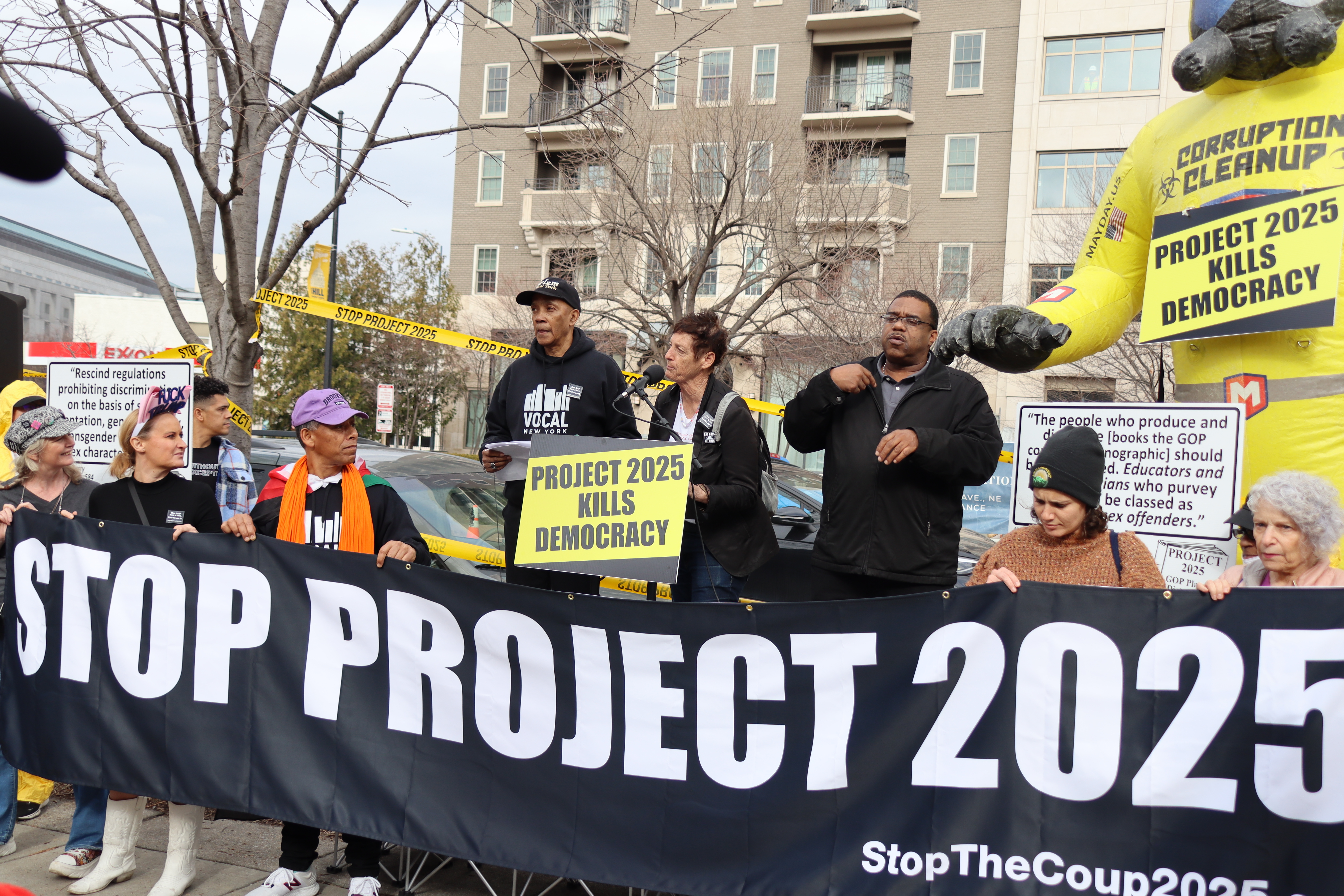 Protest with people holding a banner stating "Stop Project 2025"