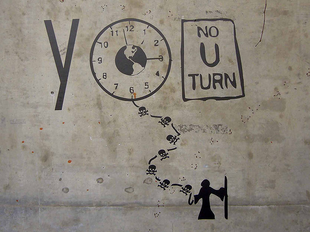 Drawing of the message "YOU." The letter "O" is drawn as a clock figure that is attached as if it were a kite, and being held by a silhouette of the grim reaper. The letter "U" is turned into a sign that reads "No U Turn."
