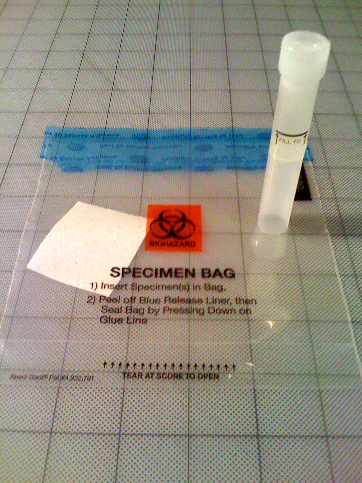 A DNA spit kit is shown, featuring a container and a specimen bag.
