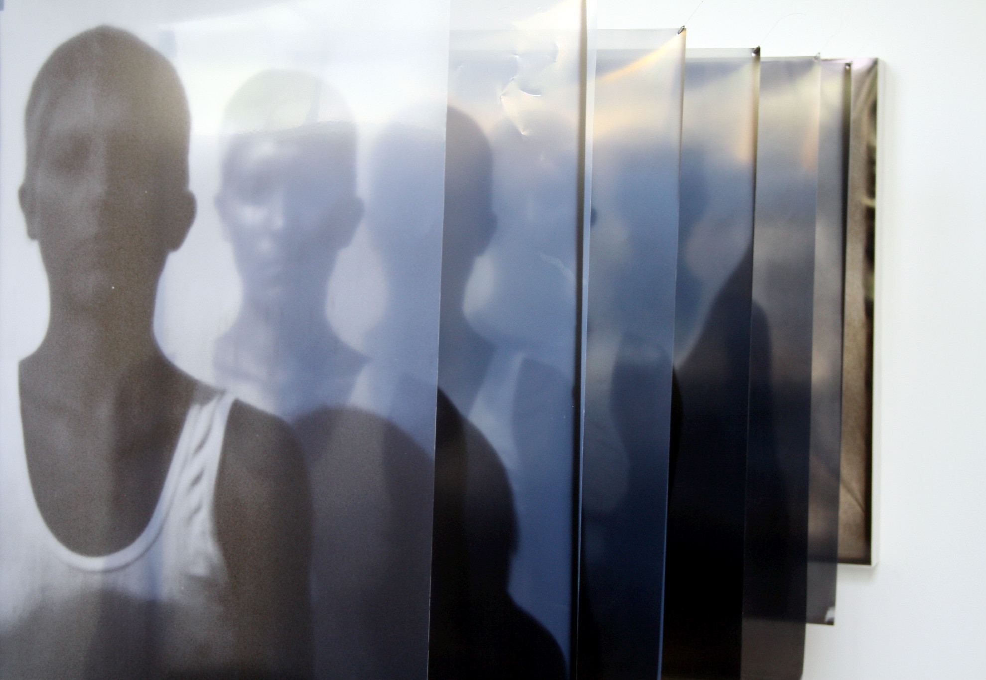 An image of a human figure in a white tank top is mirrored by seven screens, adding more depth to the figure.