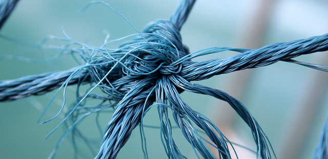 A close up photo showing a tangled knot, that is being pulled in four directions.