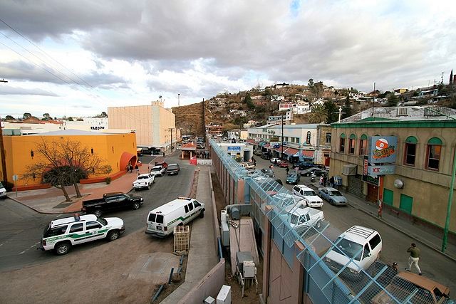 Photograph of the Mexican-U.S. border at Nopales showing fence and cities on either side.