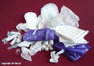 Pile of unused feminine hygiene products, including pads and tampons