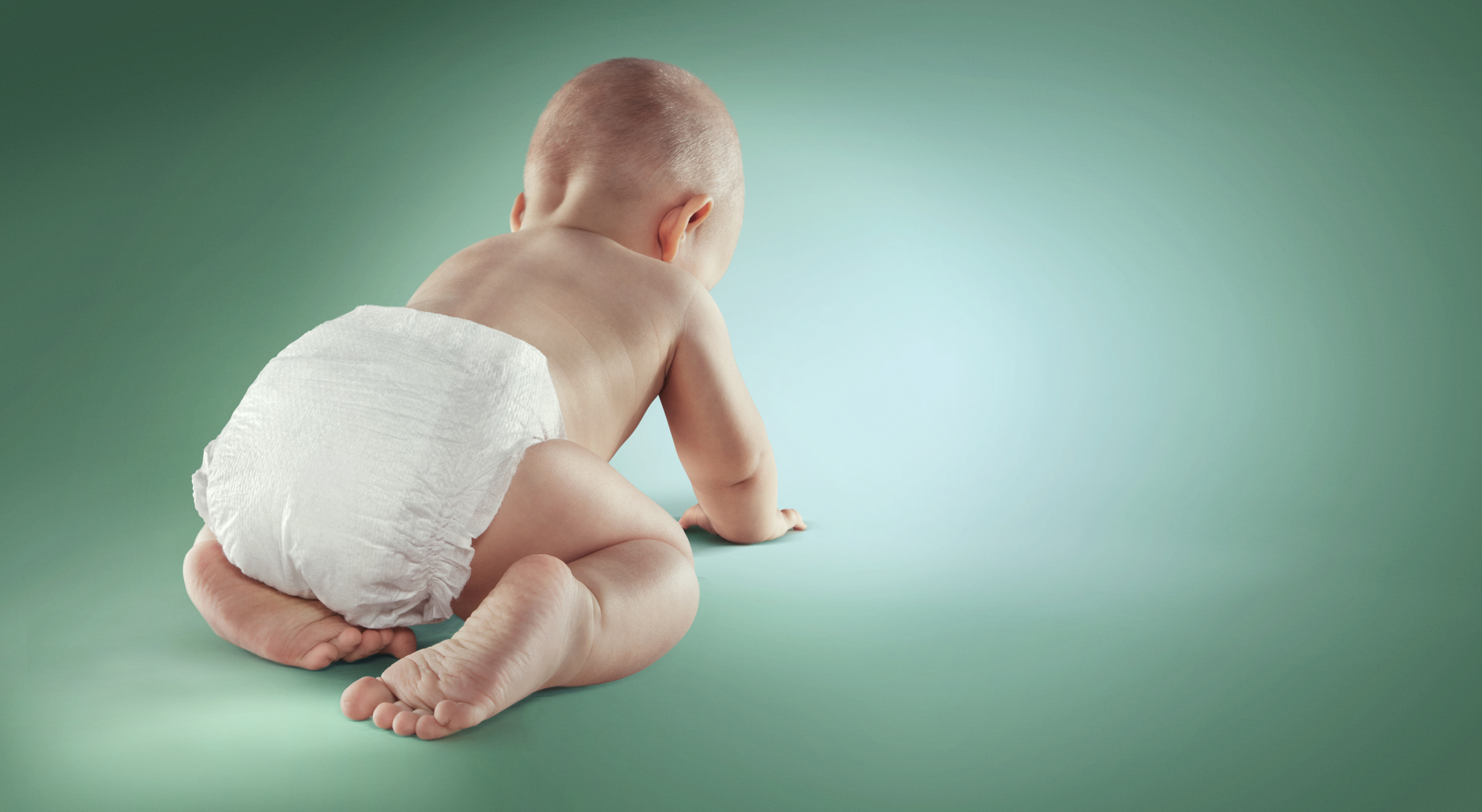 white baby crawling on a green background