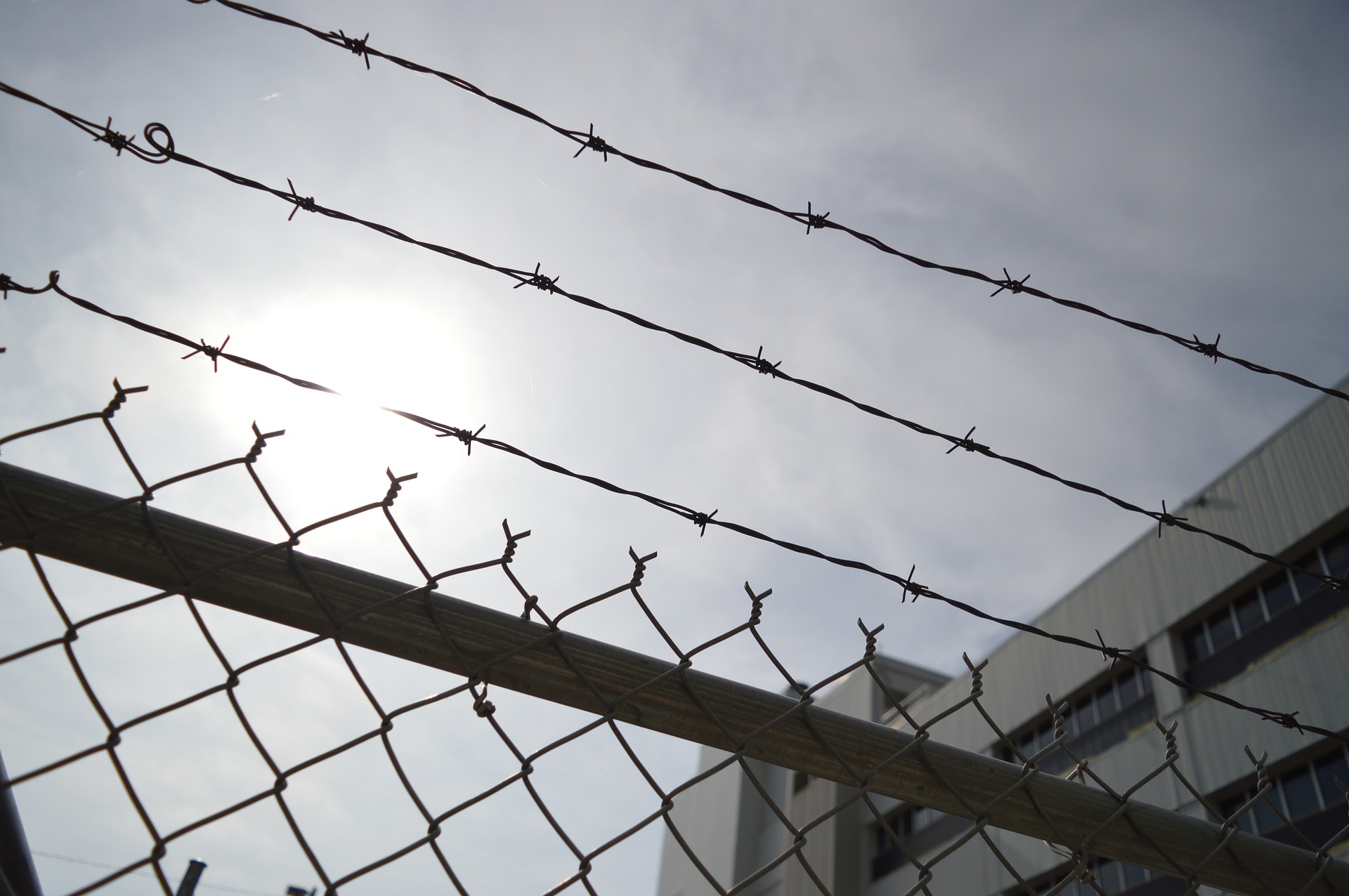 Barbed wire fence against the silhoutte of a sky.