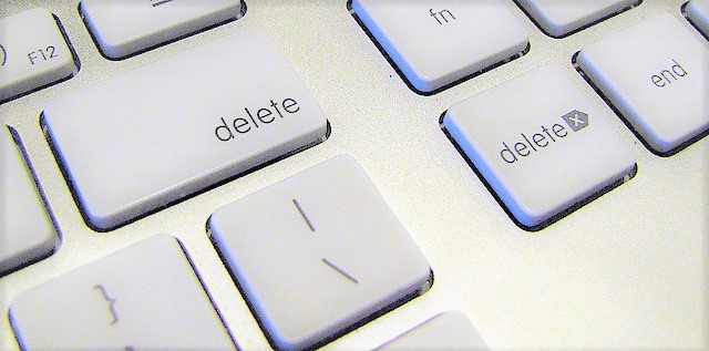 Close up photograph of a white "delete" key from an Apple computer.