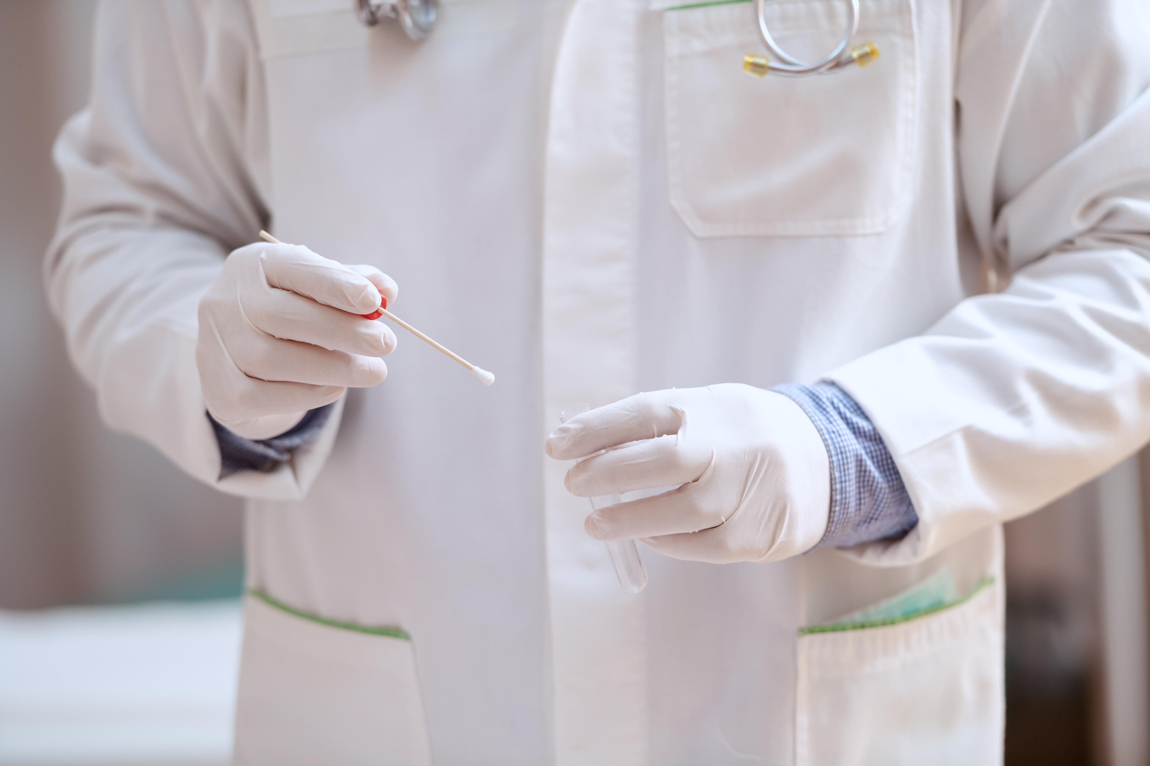 a person in a lab coat handles a specimen