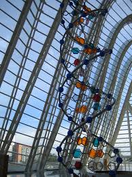 Double stranded helix inside a building with windows surrounding it.