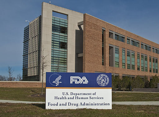 a building with a sign in front in white lettering on a blue background saying FDA