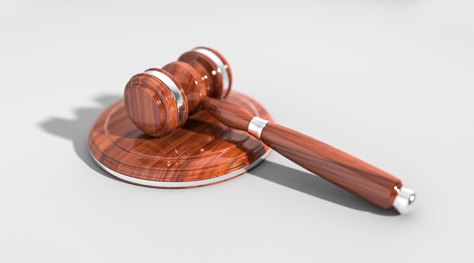 Brown judge's gavel lying on a white background. 