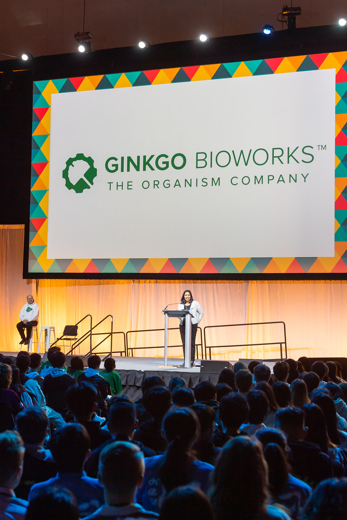 Speaker standing in front of crowd with Gingko Bioworks logo projected behind her