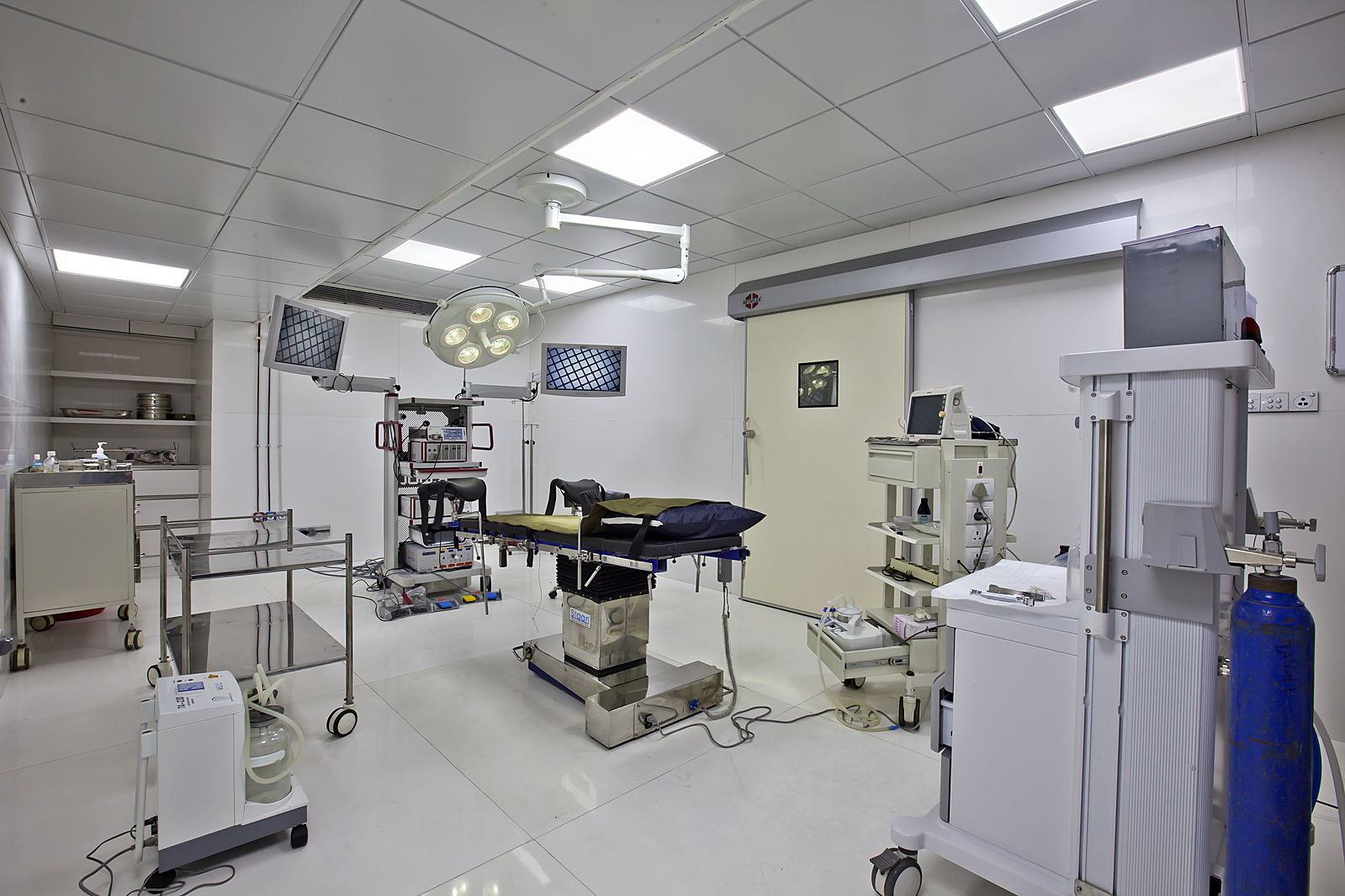 Image is of a well-lit, sterile medical operating room. 