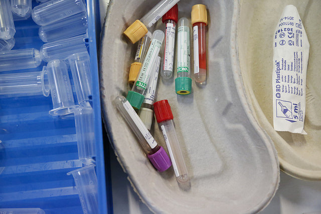 Empty medical supplies are gathered in a tray in a pile.