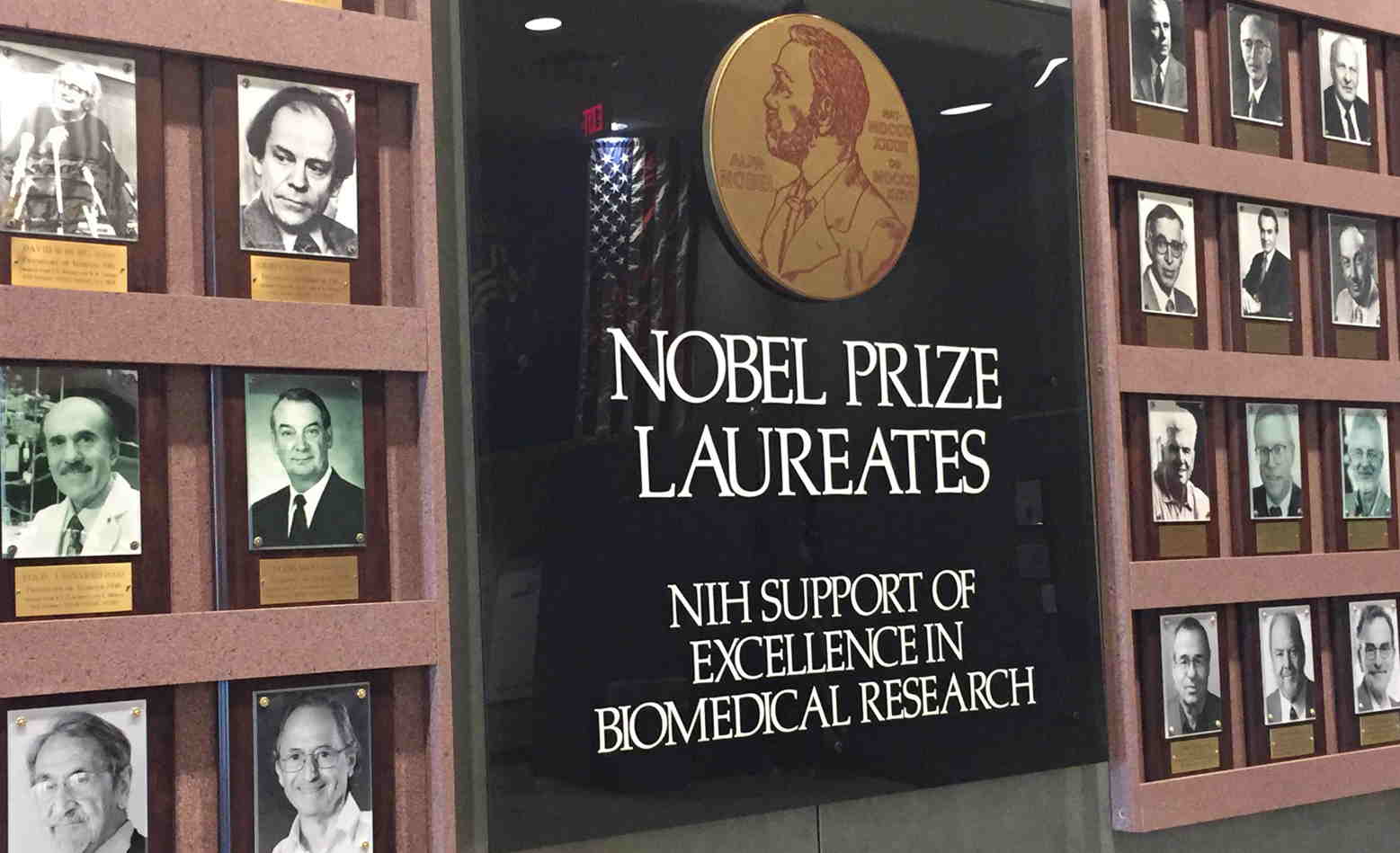 Wall plaque reading "Nobel Prize Laureates" surrounded by framed b+w photos of white men