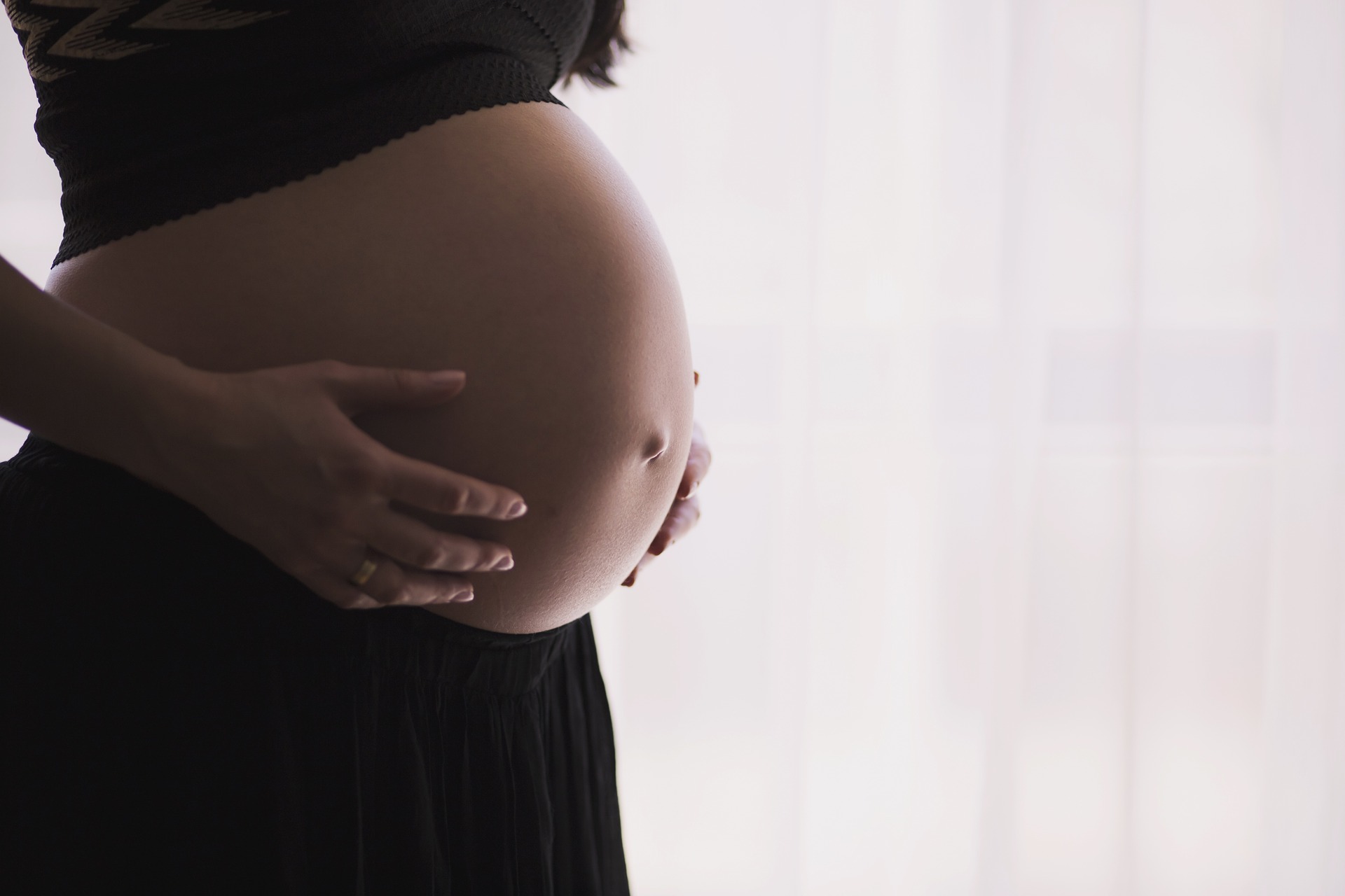 Pregnant woman holding her belly.