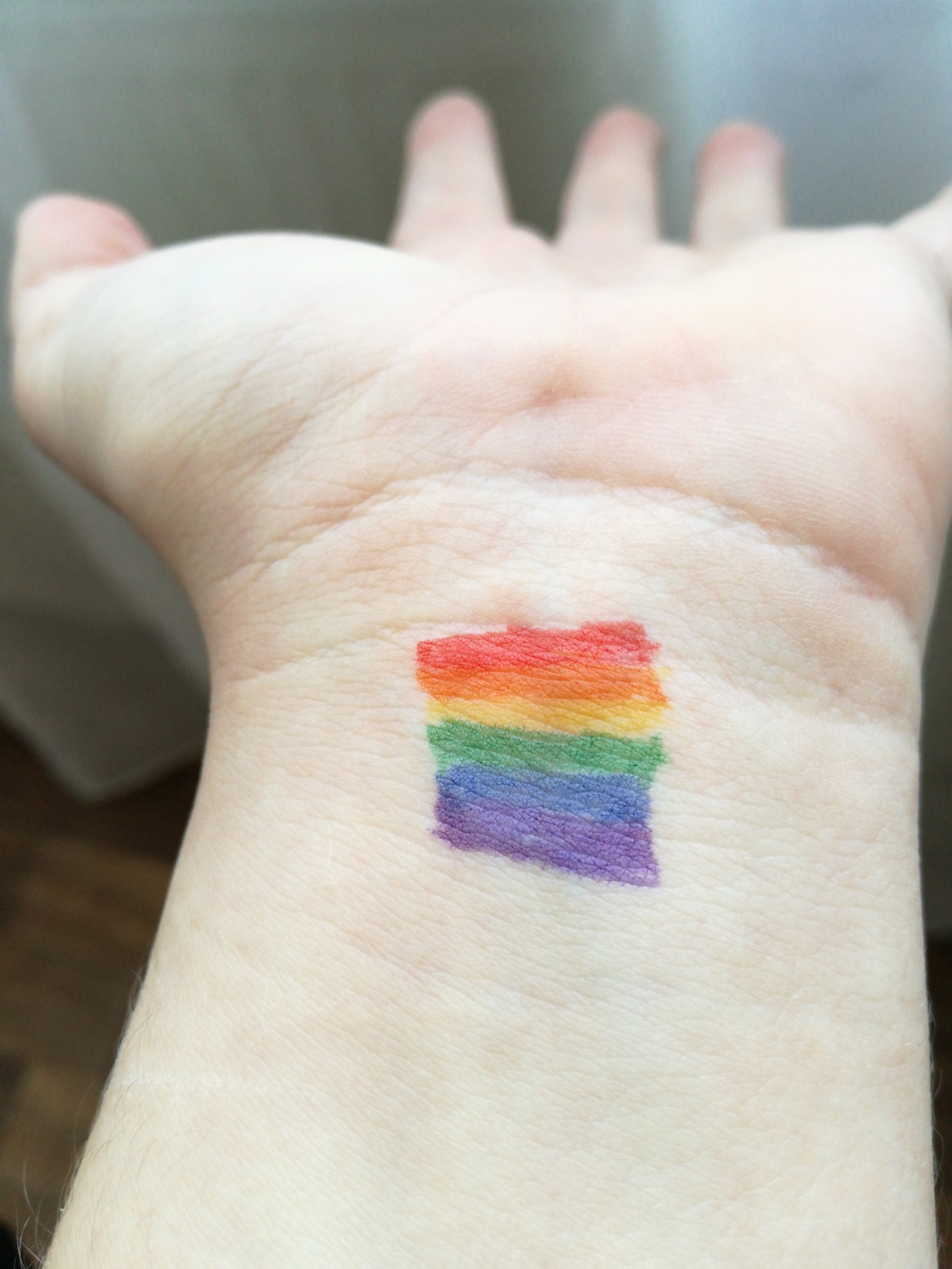 rainbow flag drawn on inside of white wrist