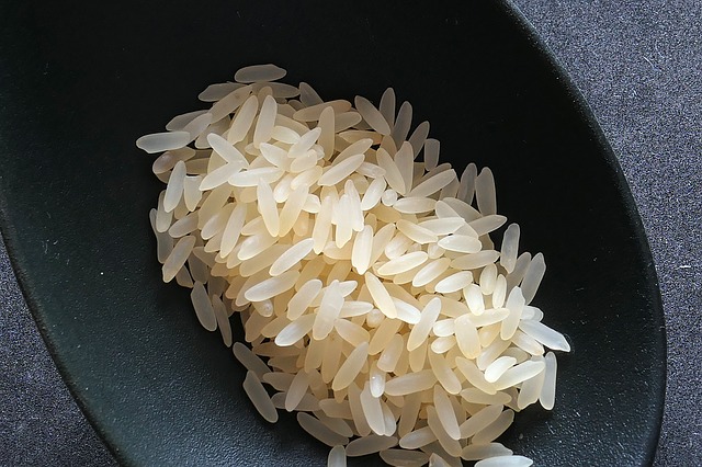 Uncooked white rice in a circular bowl container.