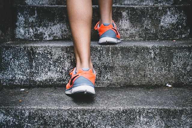 Close up of a runner, running up cement stairs.