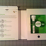 Inside of a 23andMe packaging spit kit. On the right of the box, there is text that outlines instructions on how to submit a DNA sample. On the left, there are tools.