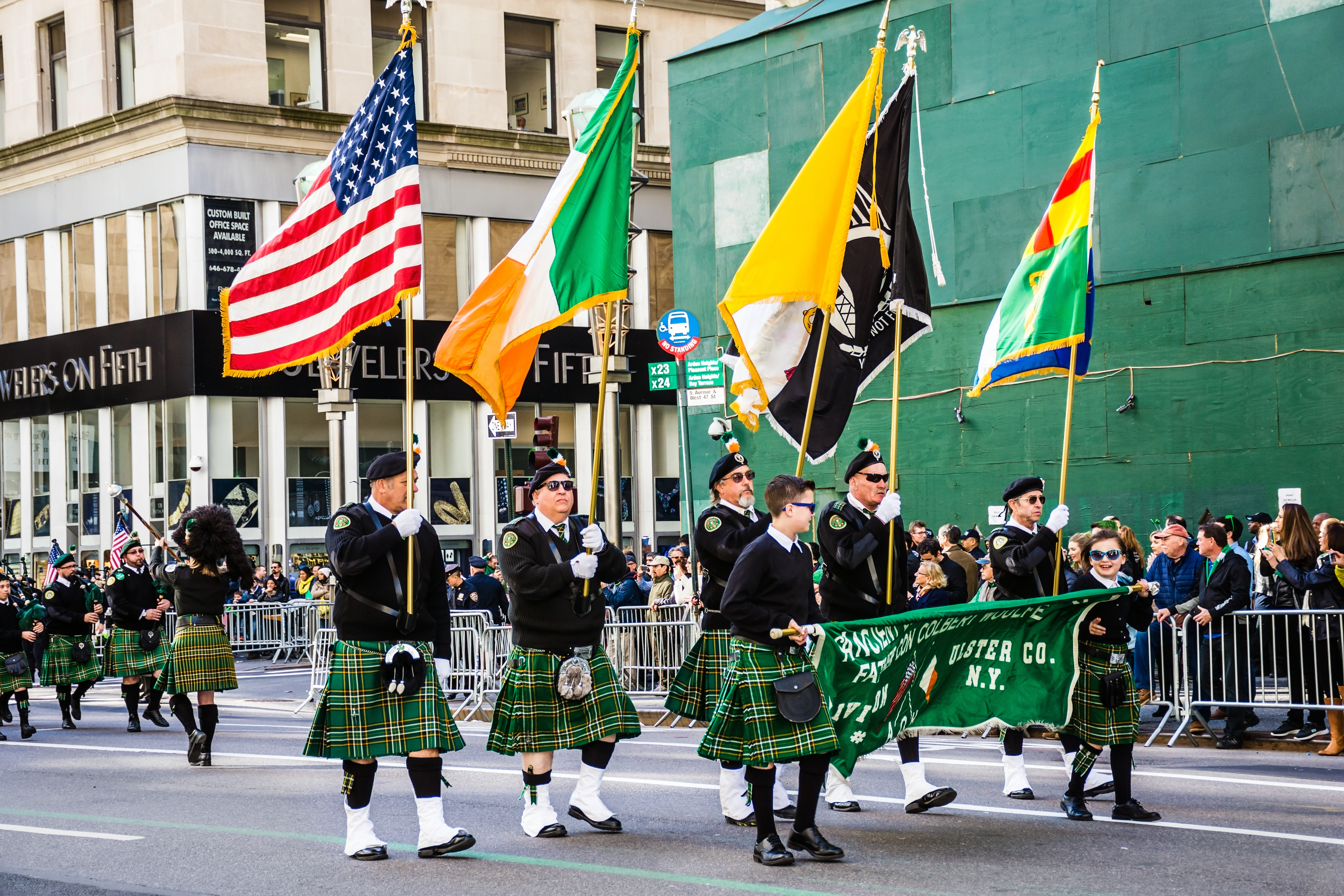 Men in kilts holding flags marching in the New York City St. Patrick's Day parade