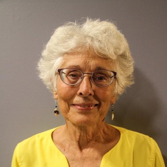 a white woman with white hair and glasses