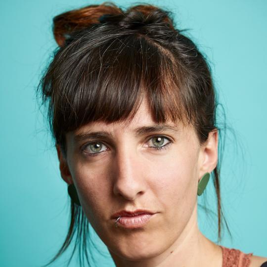 a teal background of a white woman with brown hair in an updo and bangs