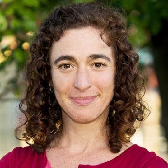 a woman with curly brown hair and a red shirt