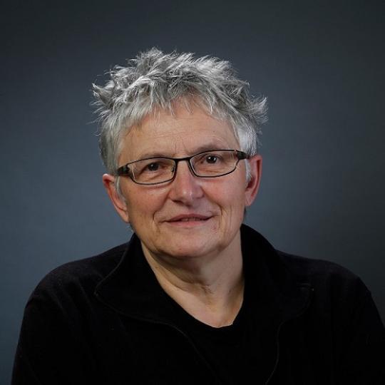 a white person with short grey hair and glasses