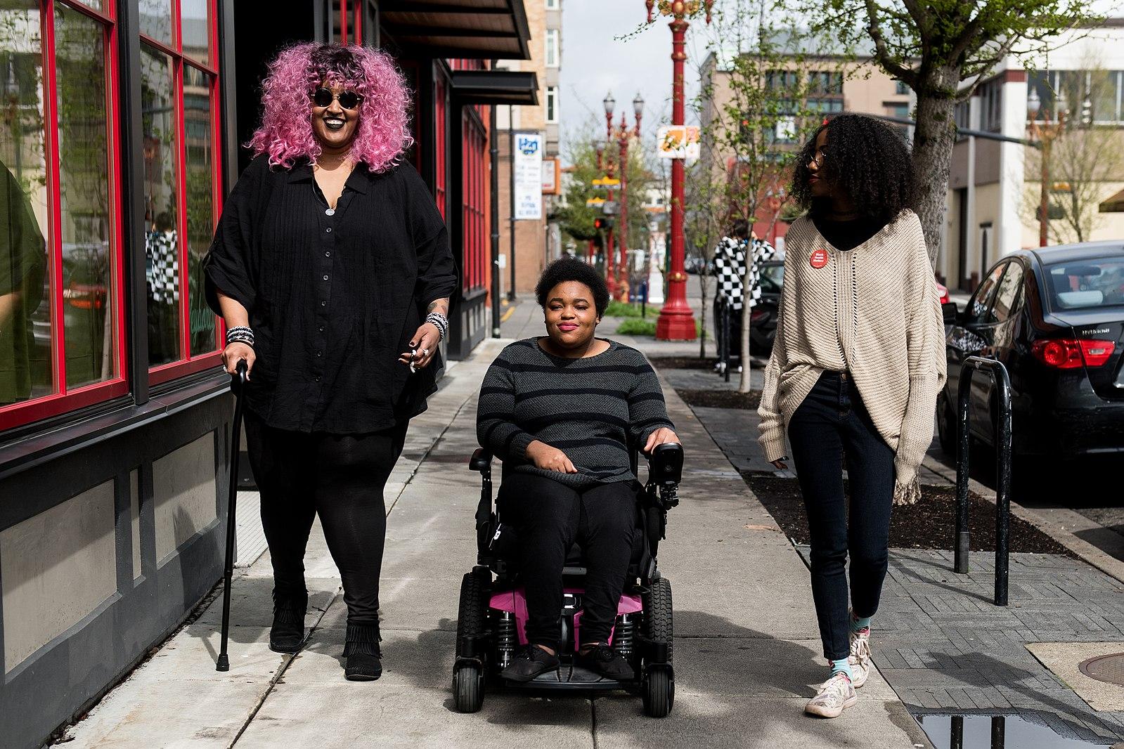 Three disabled BIPOC strolling down a street