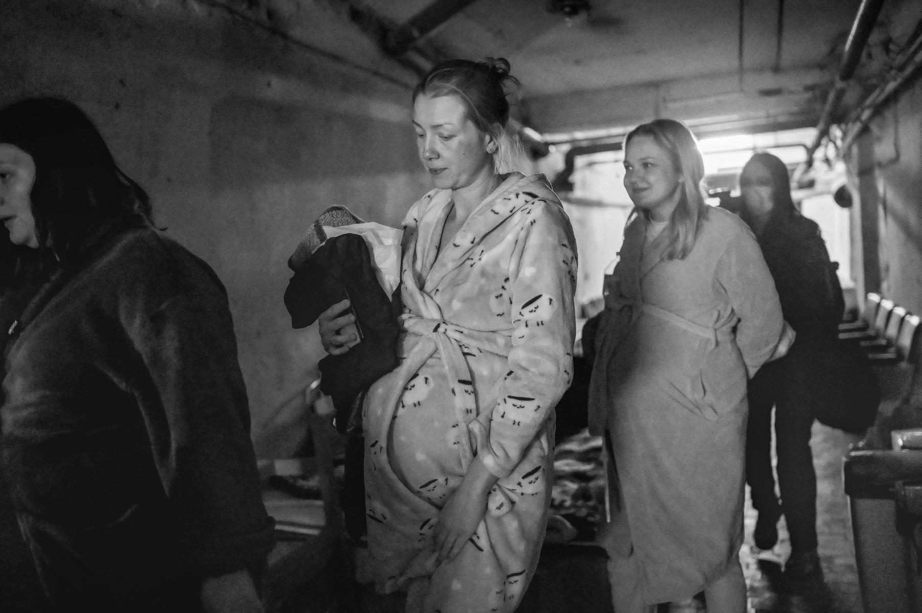 4 pregnant women dressed in robes, standing in line; grayscale