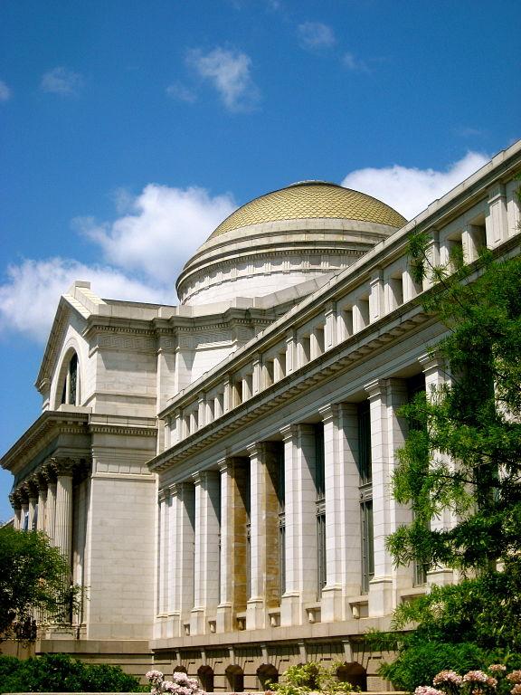 the facade of the Smithsonian Museum of Natural History with blue sky and clouds in the background