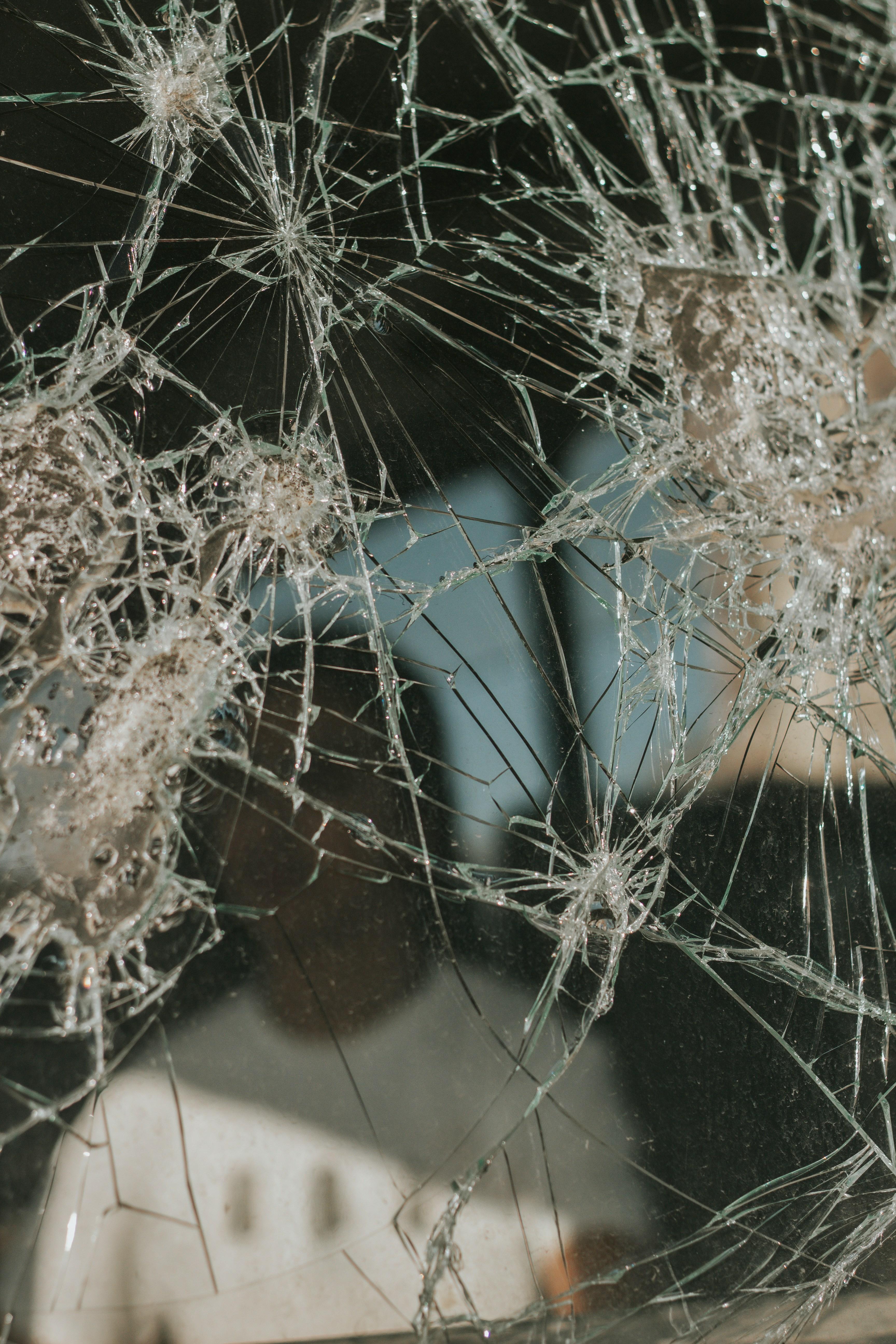 a broken mirror with a person's reflection in it