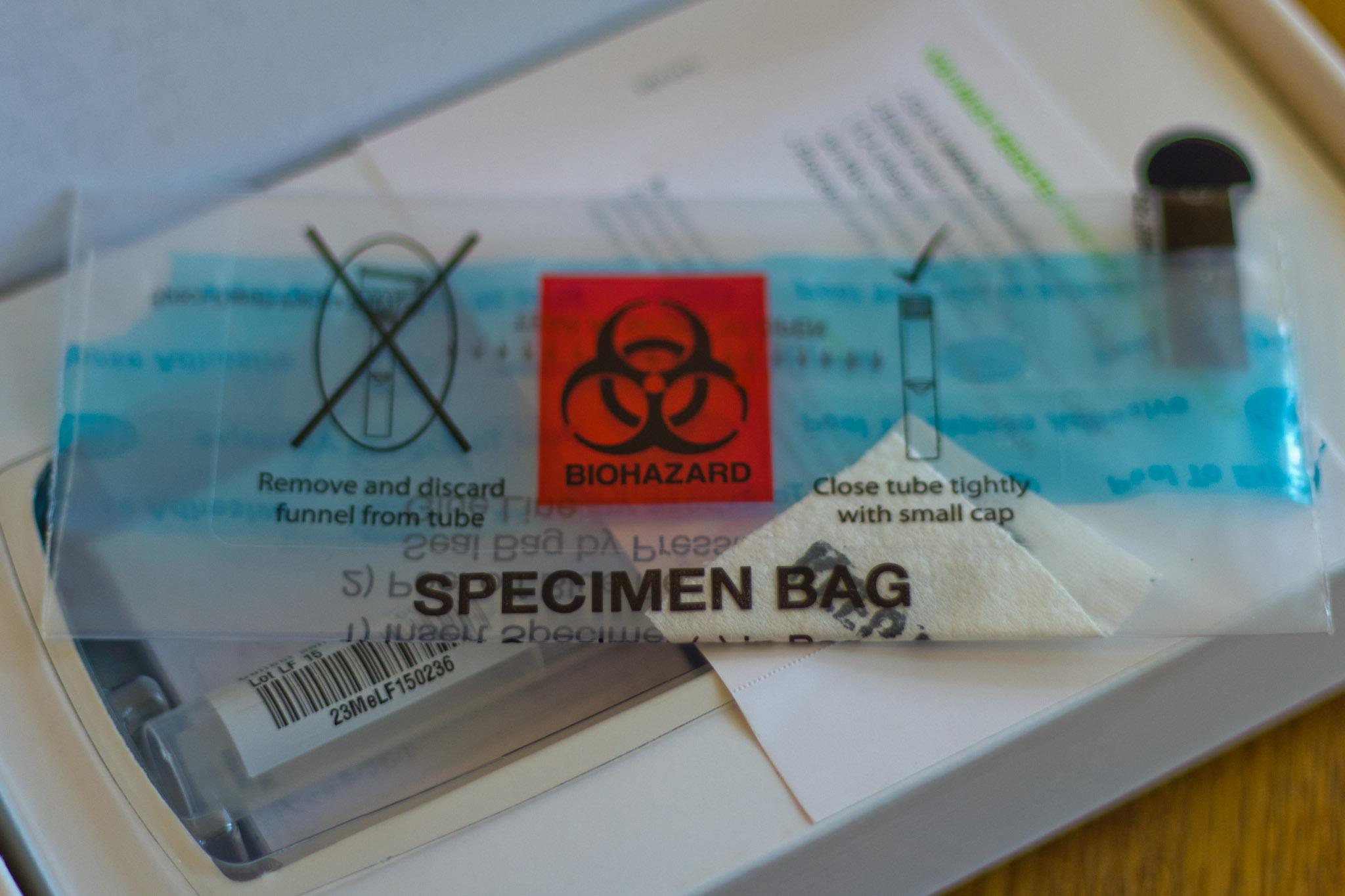 An unused 23andMe kit, displayed with box open and containing specimen bag, cotton swab, and vile container.