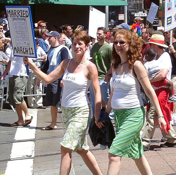 Lesbian couple holding hands and walking on the street