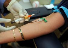 A patient's arm is getting blood drawn out.