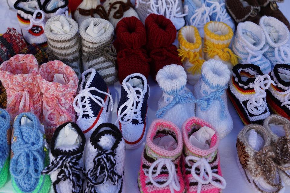 Rows of colorful crochet baby booties.