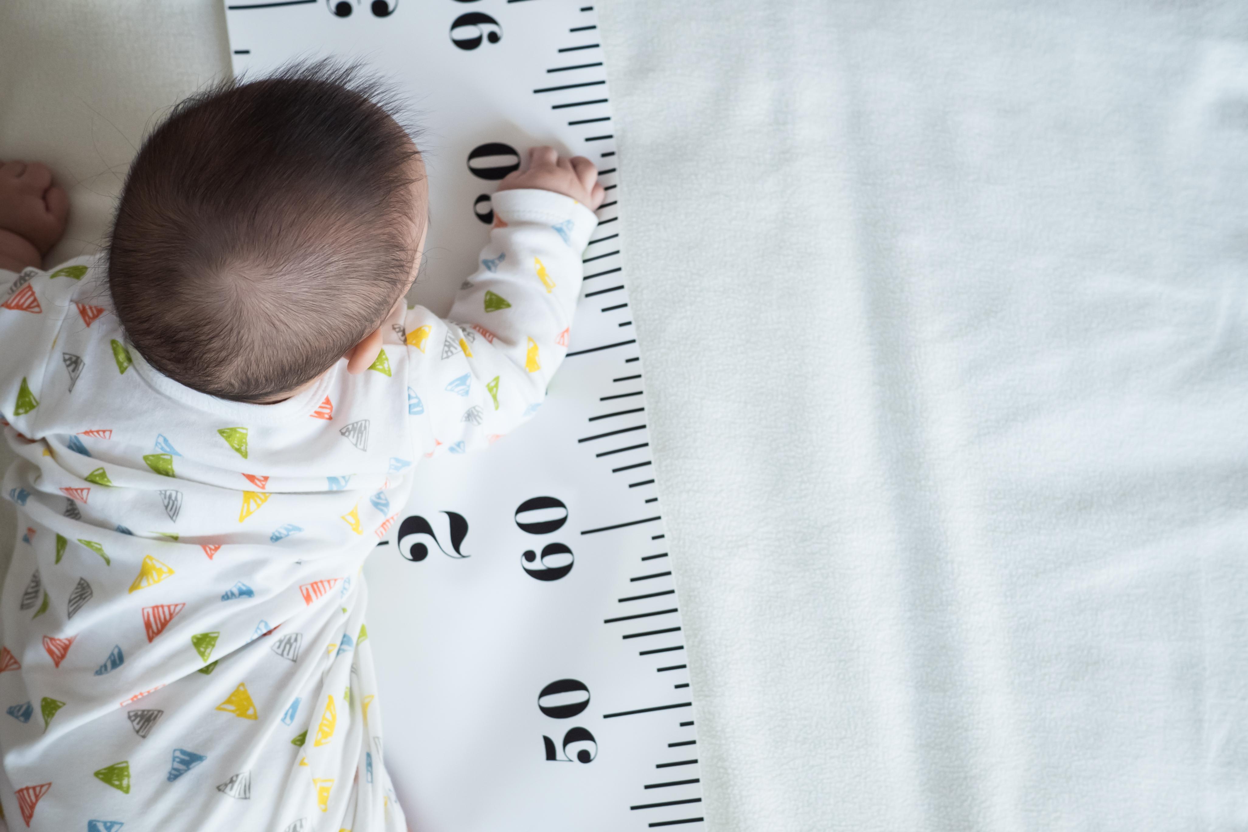 a baby laying on a ruler