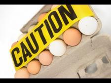 A filled egg carton is opened. Caution tape is placed across.