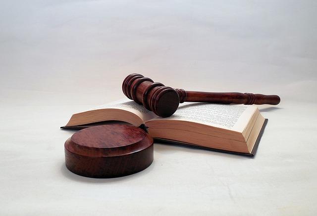 a law textbook and a gavel on a grey background