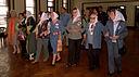 A group of women raning in age, with their heads covered by scarves,m arching in line in a building. These women are the Grandmothers of Plaza de Mayo.