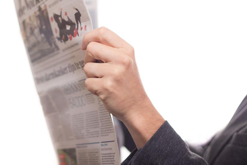 An image of someone holding a newspaper.