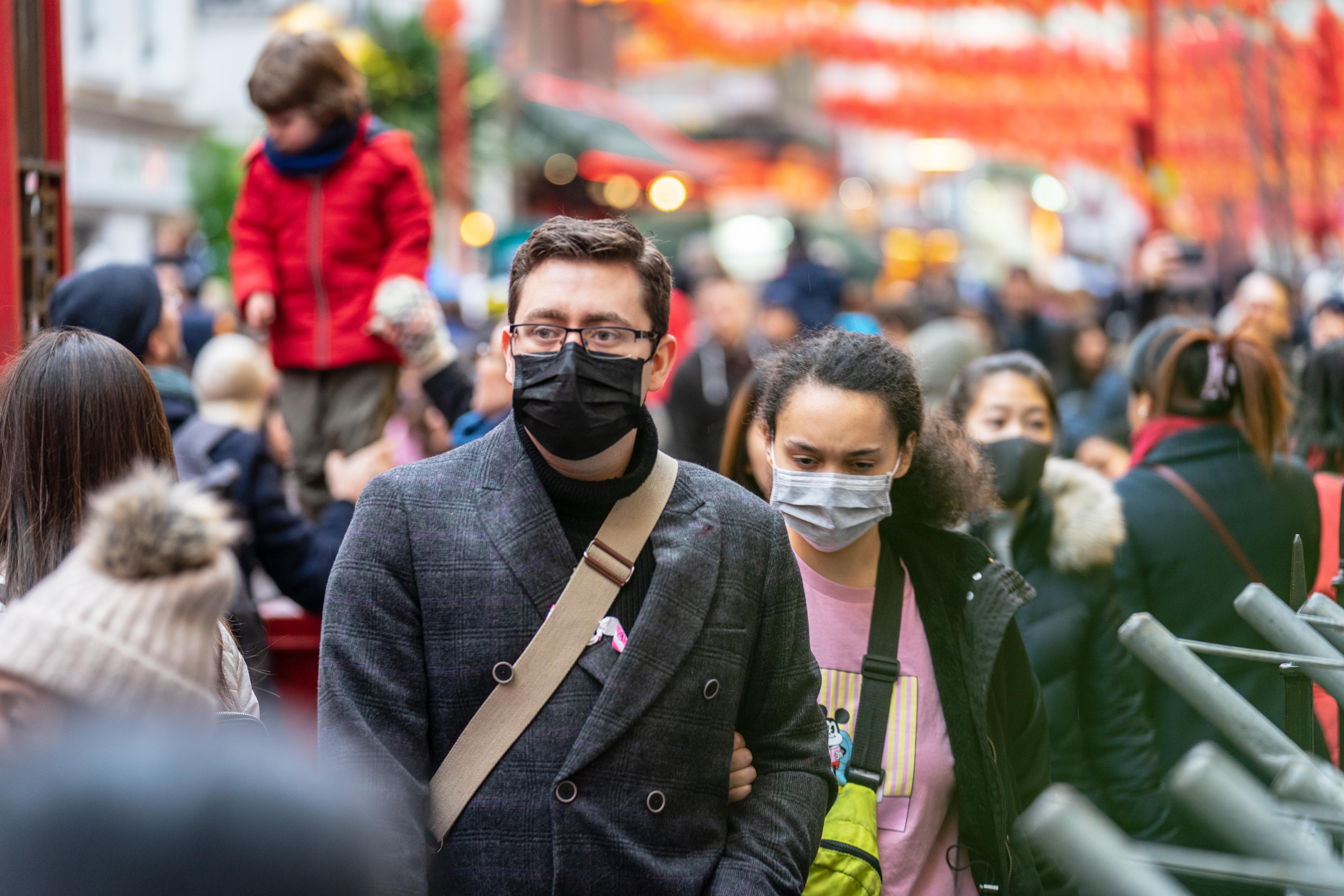 people walking on the street wearing protective face masks