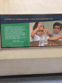 Image of a display from UC Berkeley Lawrence Hall of Science's Biotech Learning Lab featuring two children using a pipette and a beaker.