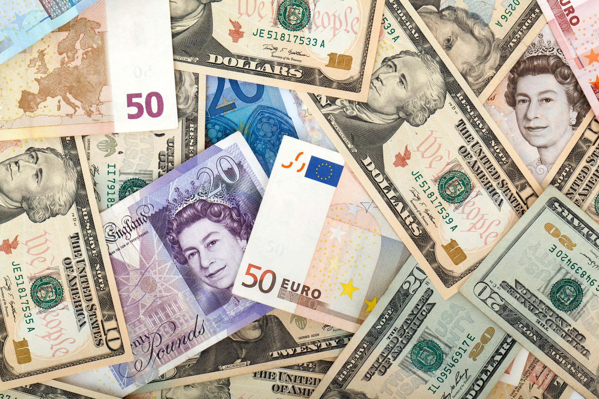 Close up image of various bills including dollars, pounds, and euros.